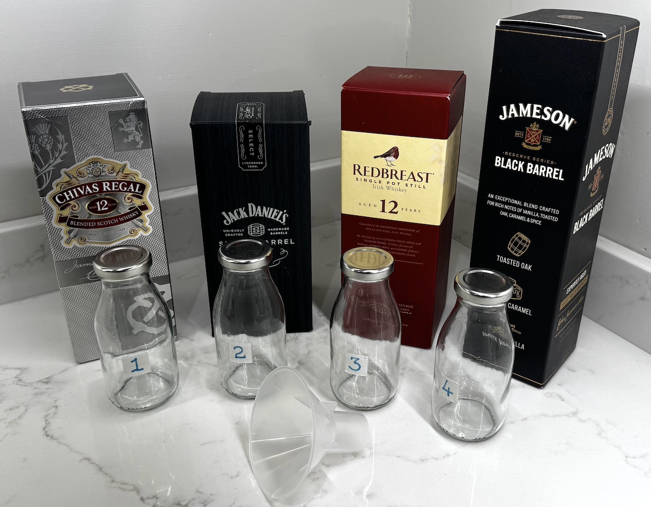 Example of four whiskies decanted into numbered bottles for a blind tasting
